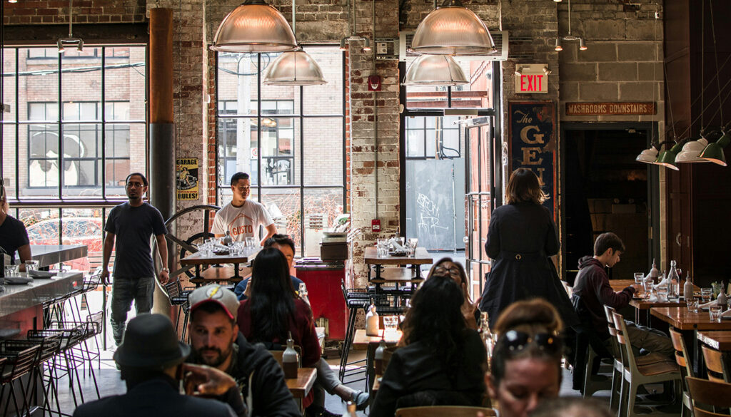 Salle de restaurant vide avec tables dressées et ambiance chaleureuse